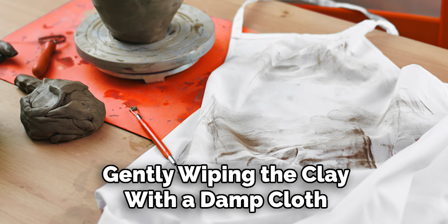 Gently Wiping the Clay With a Damp Cloth