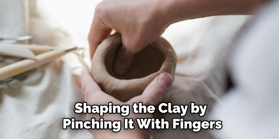 sharping the clay by pinching it with fingers